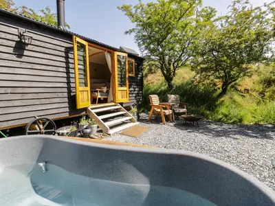 a swimming pool in front of a tiny house at Moelfre - Shepherds Hut in Llanbedr