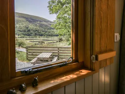 a window in a room with a view of a field at Moelfre - Shepherds Hut in Llanbedr