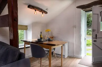 a dining room with a table and chairs at Granary Retreat for 2 inc shared Dog Field in Bryn-crug