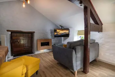 a living room with a couch and a tv at Granary Retreat for 2 inc shared Dog Field in Bryn-crug