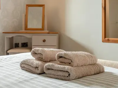 a pile of towels sitting on top of a bed at Robins Nest - Uk36208 in Llanfihangel-y-creuddyn