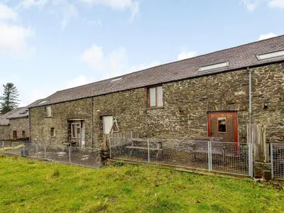 an old stone building with fences around it at Robins Nest - Uk36208 in Llanfihangel-y-creuddyn