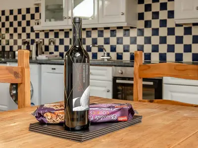 a bottle of wine sitting on top of a table at Robins Nest - Uk36208 in Llanfihangel-y-creuddyn