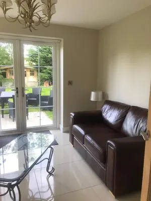 a living room with a leather couch and a glass table at Haul y Bore in Aberystwyth