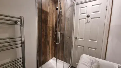 a shower with a glass door in a bathroom at Cottage #1 in Aberystwyth