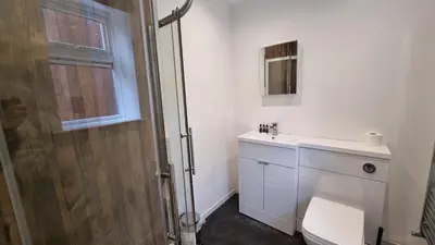 a bathroom with a shower and a toilet and a sink at Cottage #1 in Aberystwyth