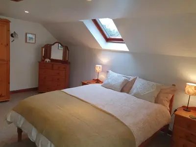 a bedroom with a large bed and a window at Ty Twt in Lampeter