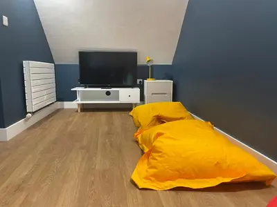 a bedroom with a yellow bed and a tv at Pennant Uchaf in Llanbrynmair