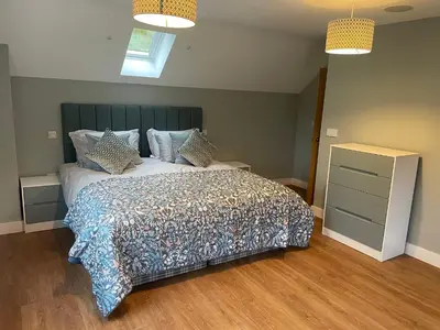 a bedroom with a large bed and a dresser at Pennant Uchaf in Llanbrynmair