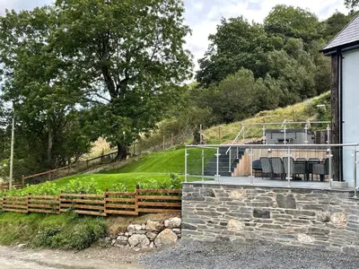 a house with a deck with chairs on it at Pennant Uchaf in Llanbrynmair