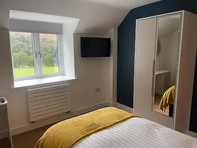 a bedroom with a bed with a yellow blanket at Pennant Uchaf in Llanbrynmair