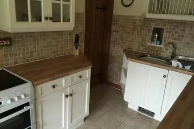 a kitchen with white cabinets and a sink at Hendre Fechan Cottage, Nr Barmouth, Pets welcome, beautiful views. in Llanddwywe