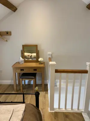 a bedroom with a table with a mirror on it at The Nook at Pentregaer Ucha, with tennis court & lake. in Oswestry