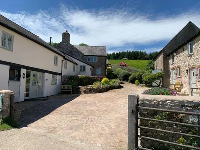 a cobblestone driveway in front of a house at The Nook at Pentregaer Ucha, with tennis court & lake. in Oswestry
