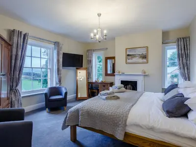 a bedroom with a bed and a desk and a chair at Old Upper Gwestydd in Highgate