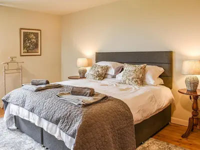 a bedroom with a large bed with two lamps at Afonig Loyw in Dyffryn