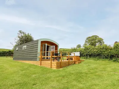 a tiny house with a deck in a field at Hwyl in Llandrindod Wells