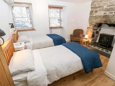 a bedroom with two beds and a fireplace at Gerlan in Harlech