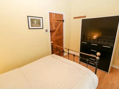 a bedroom with a large flat screen tv and a bed at Gerlan in Harlech