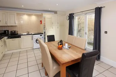 a kitchen and dining room with a wooden table and chairs at St Julians Place in Shrewsbury
