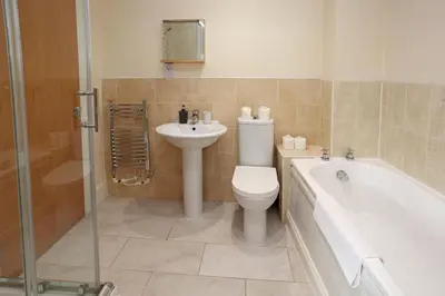 a bathroom with a toilet and a sink and a bath tub at St Julians Place in Shrewsbury