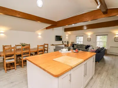 a kitchen and living room with wooden ceilings at Bridgend Cottages in Llandrindod Wells