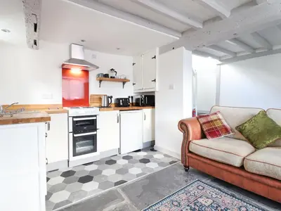 a living room with a couch and a kitchen at 1 Hendom in Corwen