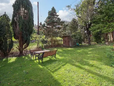 a park bench sitting in the grass in a park at 1 Hendom in Corwen
