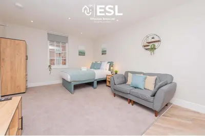 a living room with a couch and a bed at Studio 2, Second Floor Town Centre Apartment in Shrewsbury