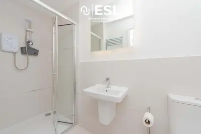a white bathroom with a sink and a shower at Studio 2, Second Floor Town Centre Apartment in Shrewsbury