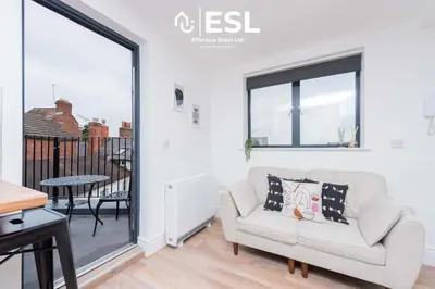 a living room with a couch and a table at Studio 3, Top Floor Town Centre Apartment in Shrewsbury