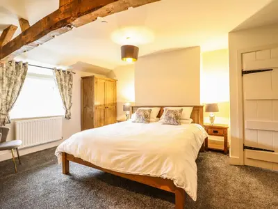 a bedroom with a bed and a window at Bodaioch Cottage in Caersws