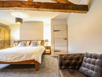 a bedroom with a bed and a couch at Bodaioch Cottage in Caersws