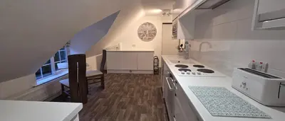 a white kitchen with a stove and a sink at Modern and spacious 2 bedroom apartment with free parking in Glyn-Ceiriog