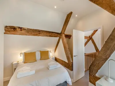 a bedroom with a white bed and wooden beams at Buckley Farm, Barn 2 - Uk36586 in Oswestry
