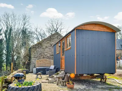a blue tiny house sitting in a yard at Ty Olwyn Bach - Uk36418 in Talybont