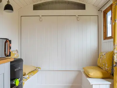 a room with a white wall in a tiny house at Ty Olwyn Bach - Uk36418 in Talybont