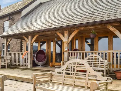 a wooden gazebo with chairs on a deck at Ty Nofio - Uk36421 in Talybont