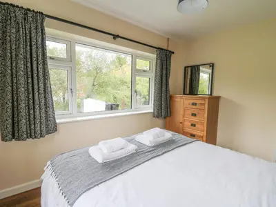 a bedroom with a bed with two towels on it at Ger Yr Afon Cottage in Rhayader