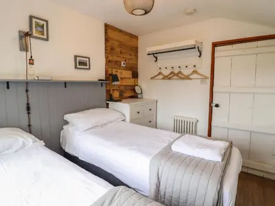 a bedroom with two beds and a kitchen at Pengeulan in Machynlleth