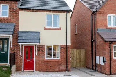 a red brick house with a red door at 2 Bedroom Home Near the Heart of Ludlow - Pass the Keys in Ludlow