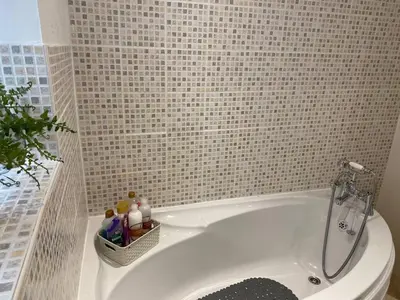 a white tub in a bathroom with a tile wall at Apartment - Sleeps 2 - Pet friendly - Parking in Ludlow