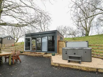 a tiny house with a grill next to a picnic table at The Fox Den in Rhayader