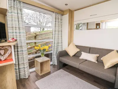 a living room with a couch and a window at The Fox Den in Rhayader