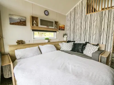 a bedroom with a bed and a couch at Meadow Retreat in Rhayader