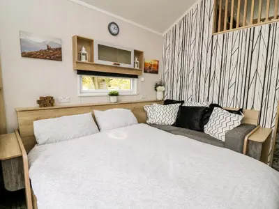 a small bedroom with a bed and a couch at Hillside Lodge in Rhayader