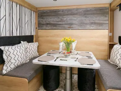 a small table in a caravan with flowers on it at Woodland Escape in Rhayader