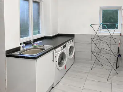 a kitchen with a washing machine and a sink at New Cottage in Penmaenpool