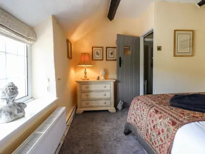 a bedroom with a bed and a window and a dresser at Neuadd Wen in Derwen