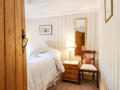 a bedroom with a bed and a mirror and a chair at Neuadd Wen in Derwen